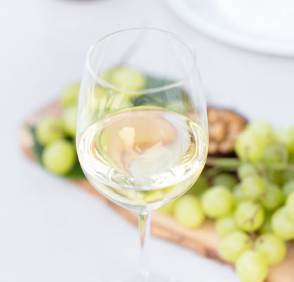 Glass of White wine beside grapes