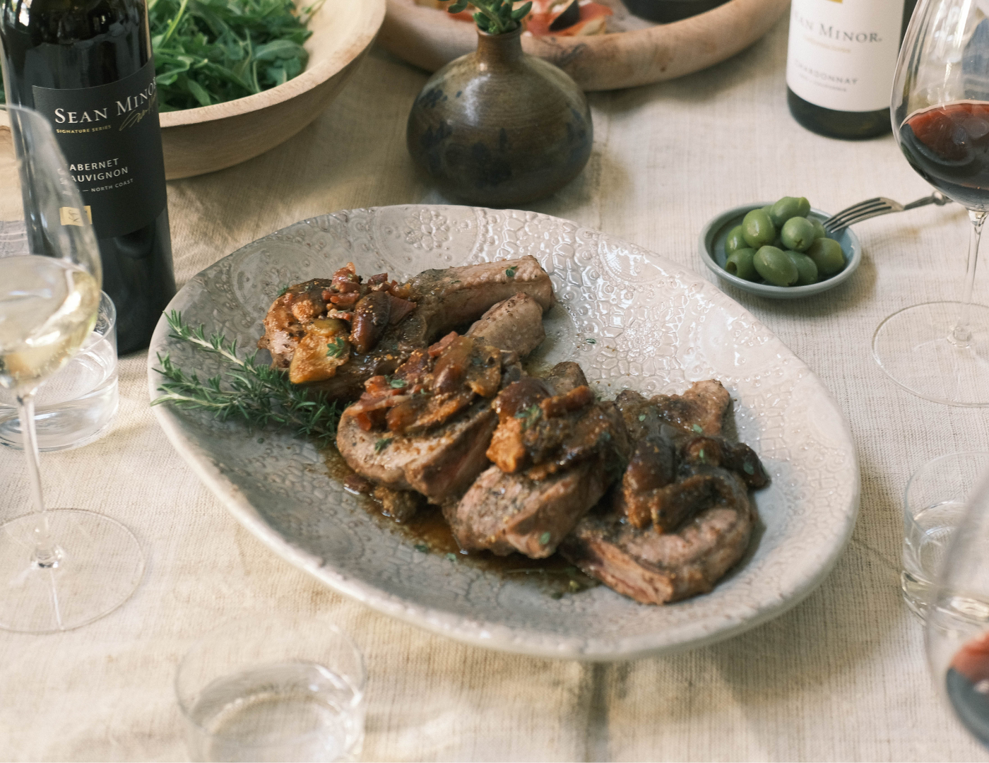 Pork Chops topped with Fig Balsamic on plate with wine bottle on side