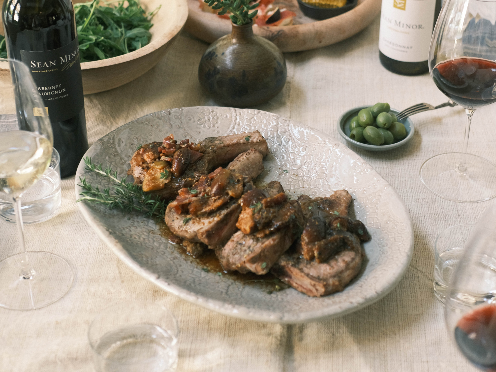 Pork Chops topped with Fig Balsamic on plate with wine bottle on side