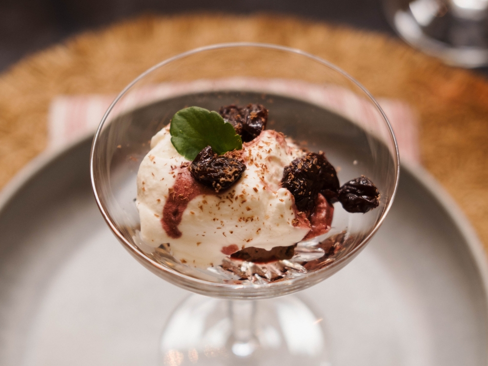 A glass with chocolate mouse toped with wine soaked cherries