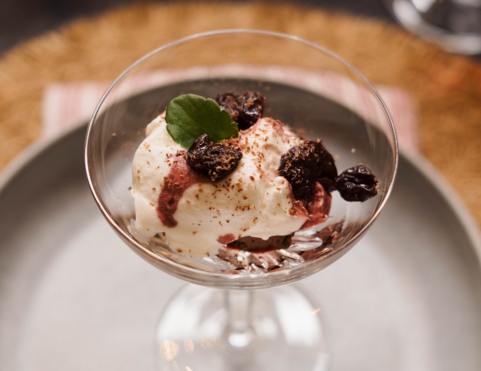 A glass with chocolate mouse toped with wine soaked cherries