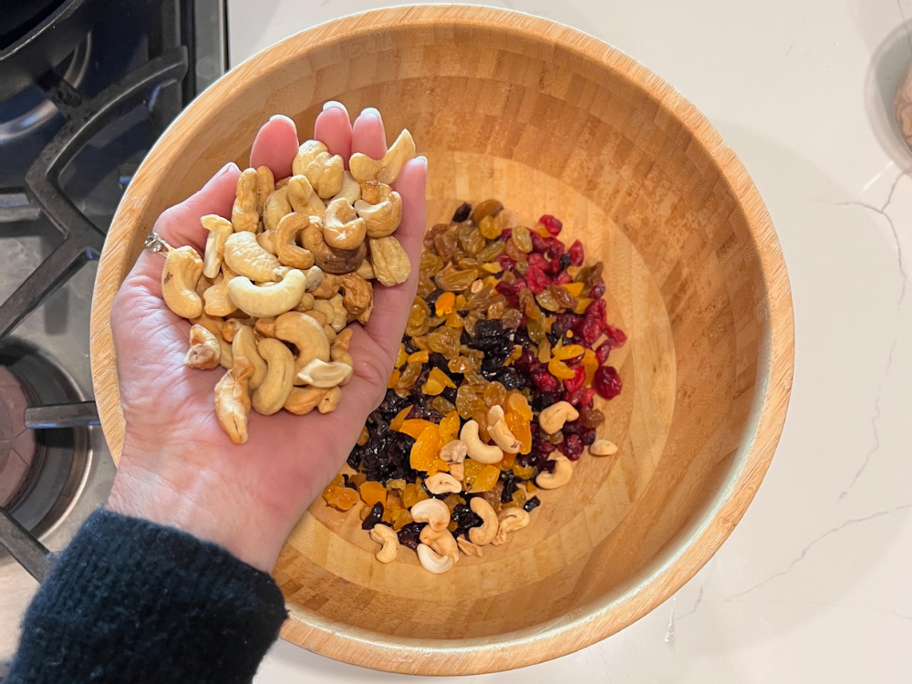 granola being hand mixed in a bowl