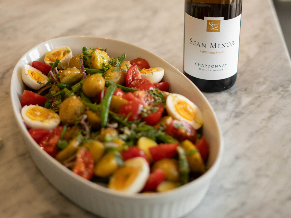 platter of potato salad with bottle of chardonnay