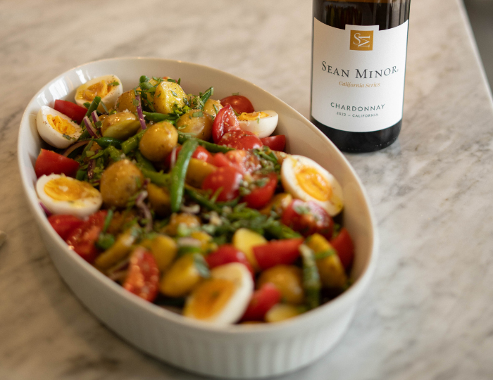 platter of potato salad with bottle of chardonnay