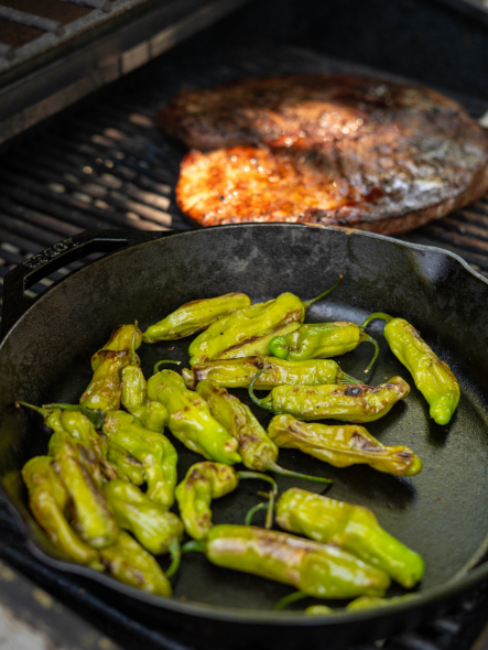cast iron shishito peppers on a grill
