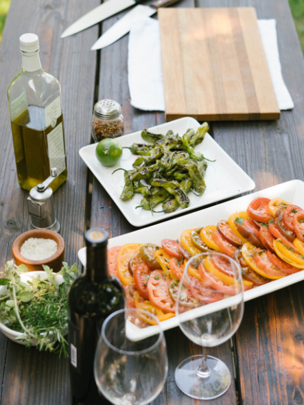 spread of appetizers tomatoes and shishito peppers
